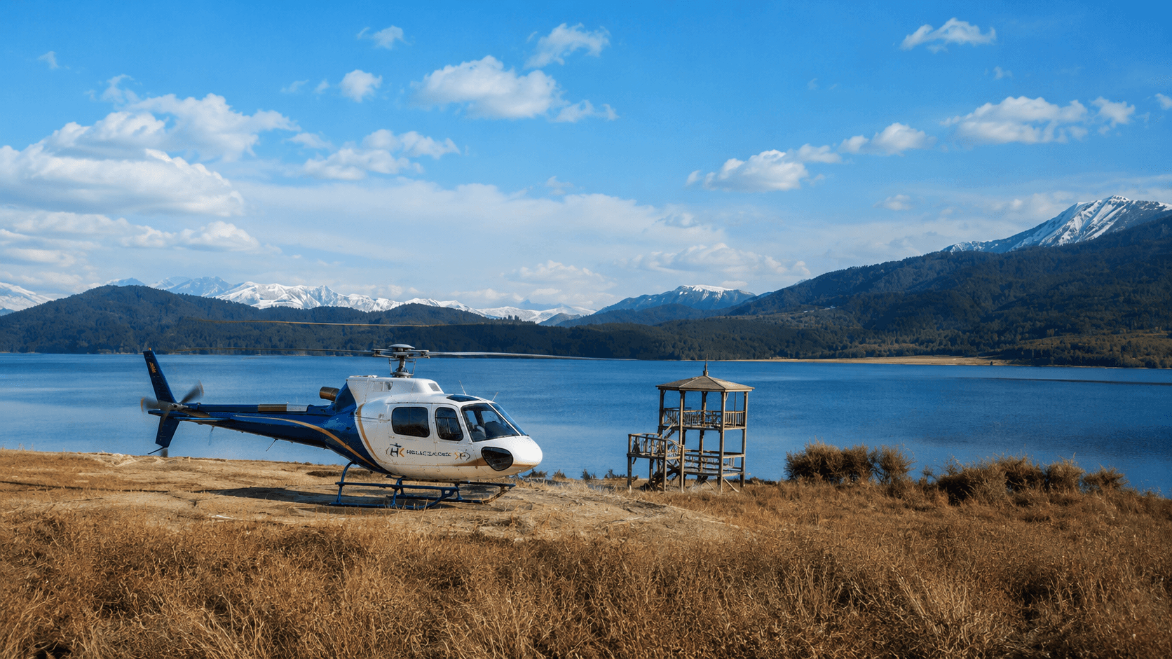 Turquoise waters of Rara Lake surrounded by forested hills from above